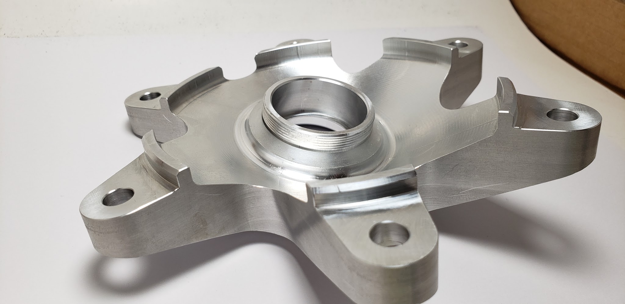 Precision machined aluminium hub with a threaded central boss and five bolt bosses